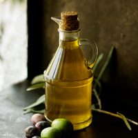 Glass bottle of olive oil and olives